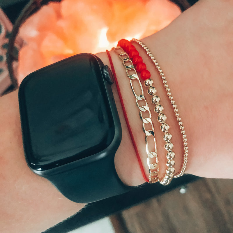 Model photo of wrist with stack of gold bracelets