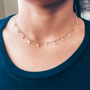 Model photo wearing Gold necklace with stars and stones as charms