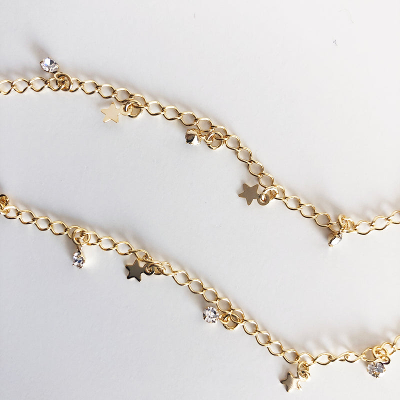 Close up view of Gold necklace with stars and stones as charms