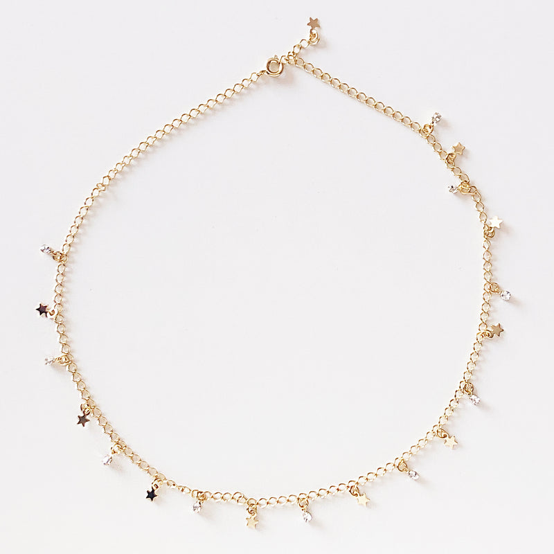 Gold necklace with stars and stones as charms
