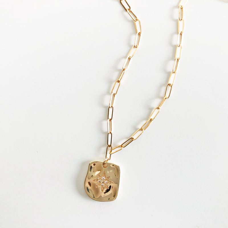 Gold chain necklace with rectangular warped charm with star