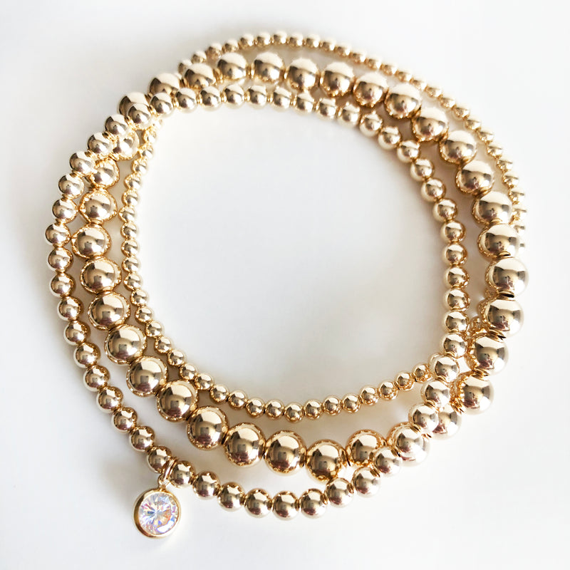 14K Gold-Filled beaded stack of bracelets with a round Swarovski crystal charm