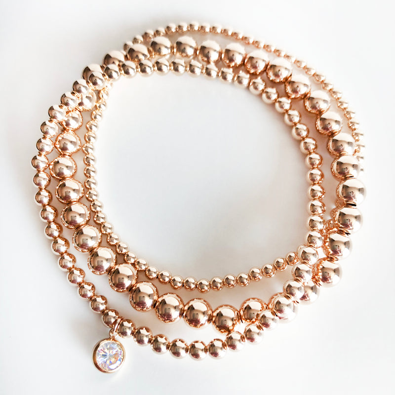 14K Rose Gold-Filled beaded stack of bracelets with a round Swarovski crystal charm