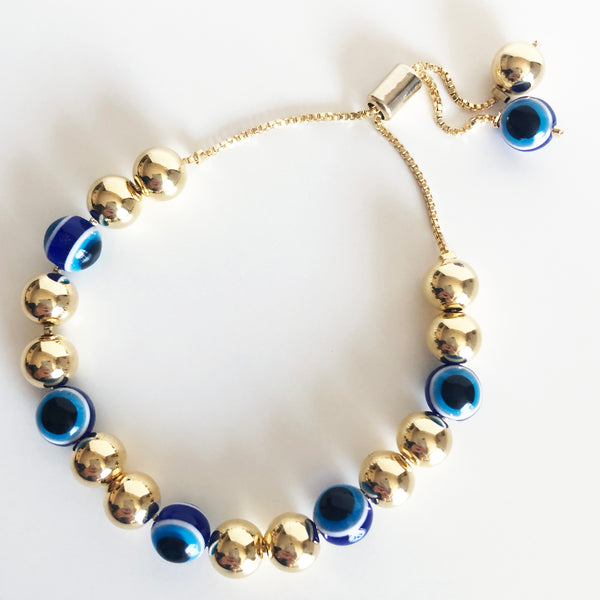 7mm alternating gold and evil eye beaded drishti bracelet with bolo closure on a box chain