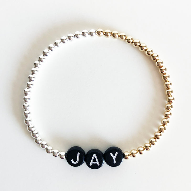Mixed metal beaded name bracelet gold and silver with black letter beads