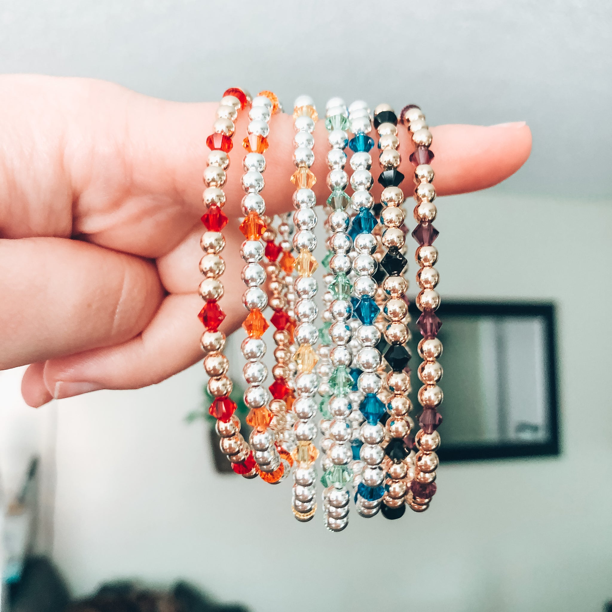 Model photo of Stack of 14k gold-filled and sterling silver beaded bracelets with Swarovski crystals