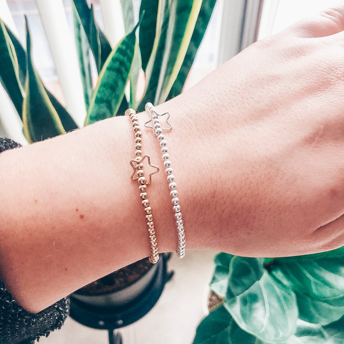 Model photo wearing 3mm 14k gold-filled and sterling silver beaded bracelet with orbiting star charm