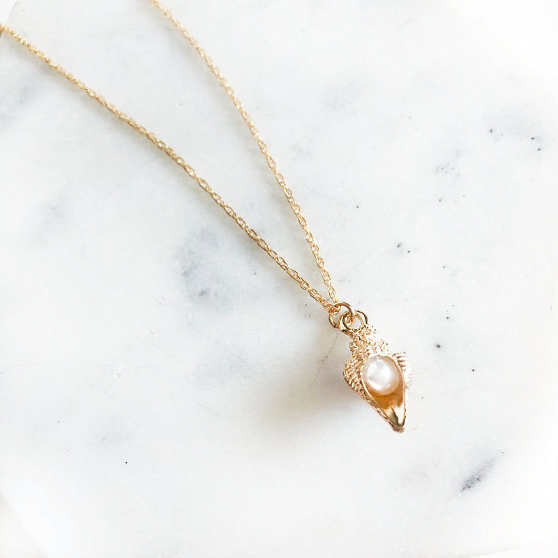 14k gold-filled chain necklace with conch shell charm with pearl in the middle up close detail view