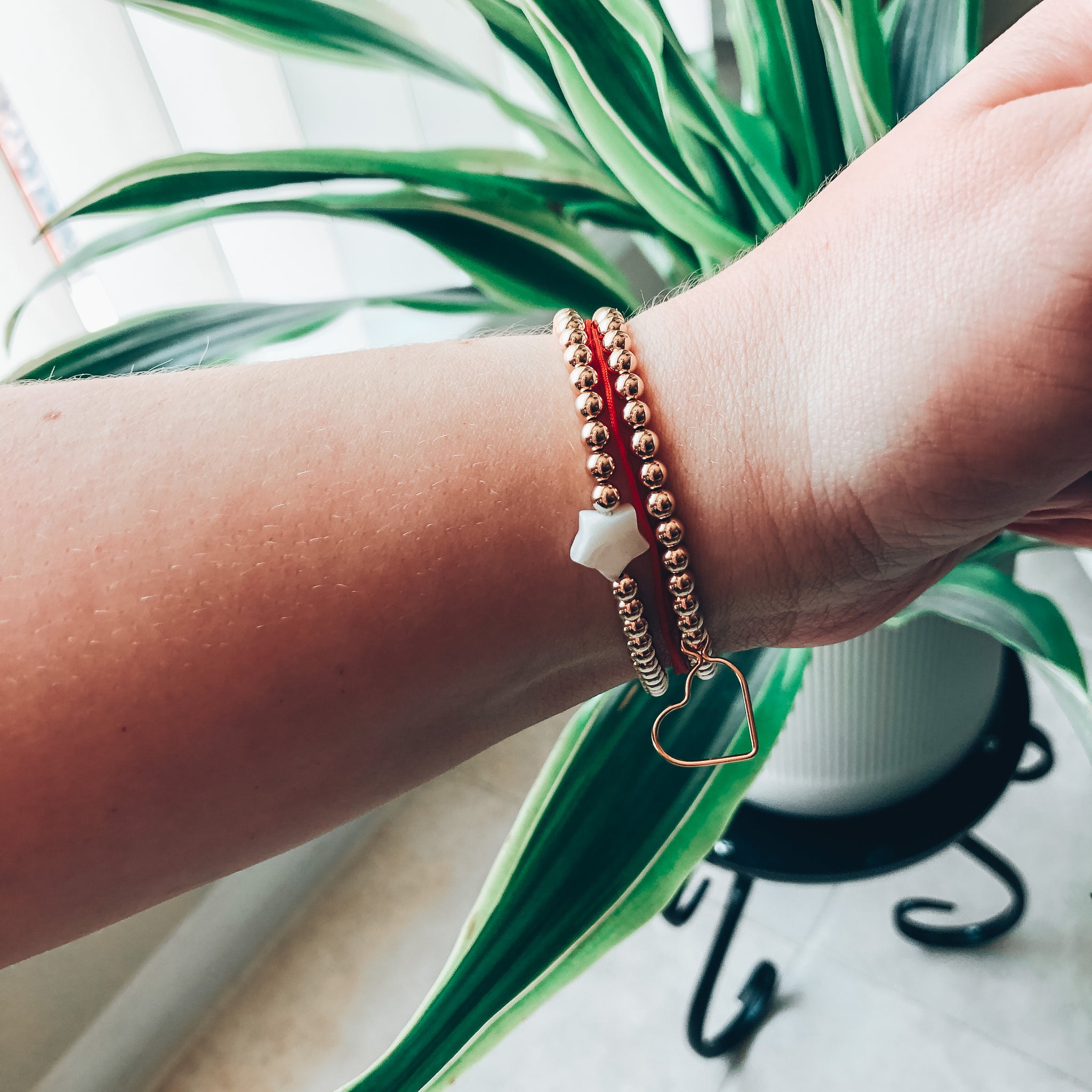 Model photo wearing 14k gold-filled 4mm beaded bracelet with open heart charm